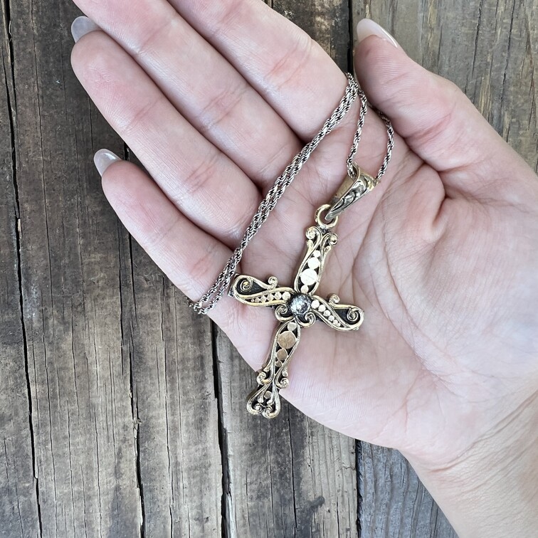 Cross Pendant Necklace witha simulated diamond in the hand of a woman